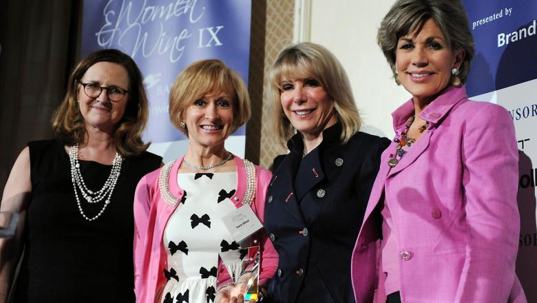 Four women stand together at the event