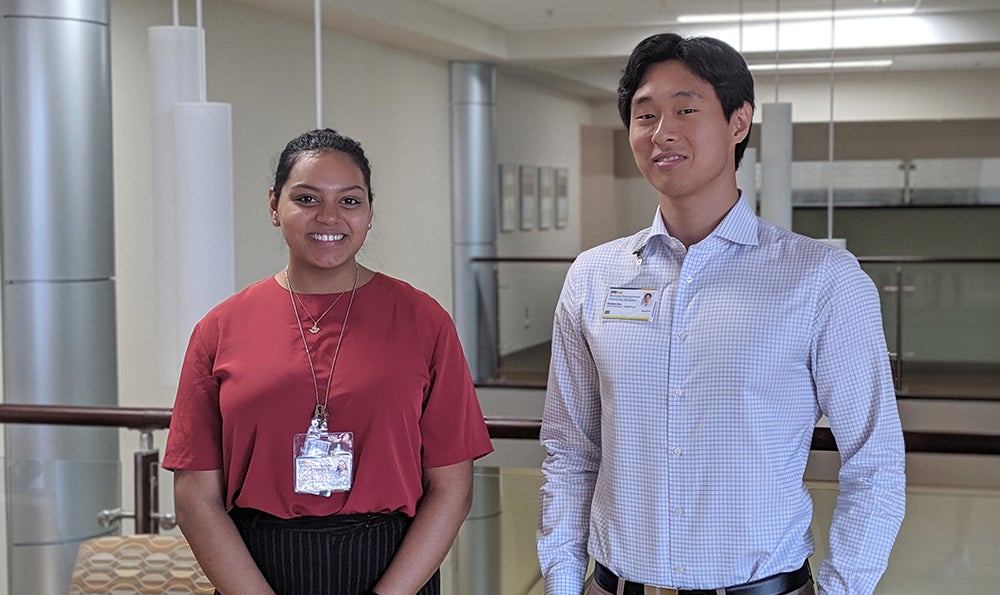 Two young people stand side by side