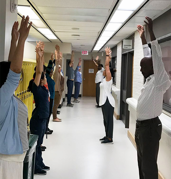 Staff do yoga in a hallway