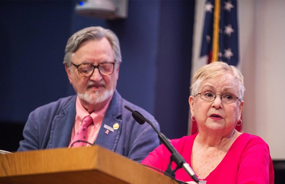 Two people stand at a podium