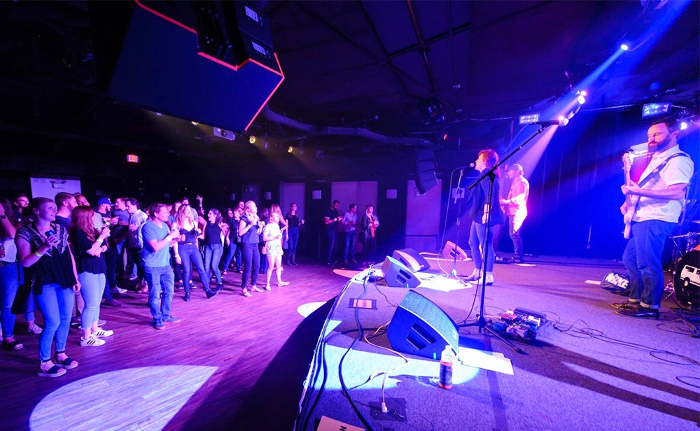 A band plays onstage in front of an audience