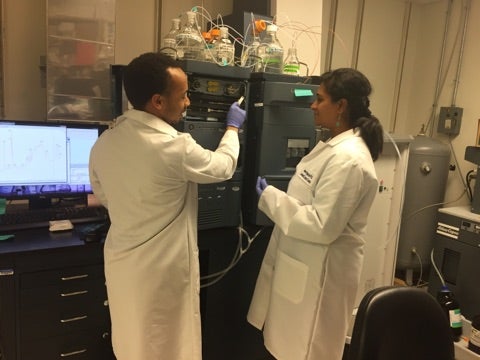 Two people using a lab instrument