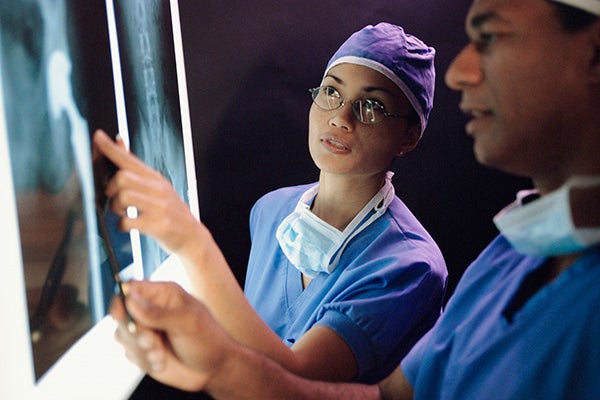 A group of physicians examining an x-ray in a lab room.