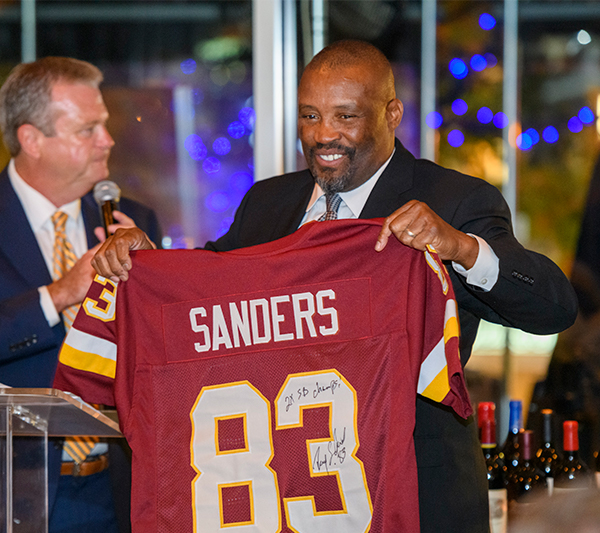 Ricky Sanders hold a red football jersey