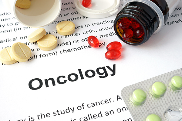 Medical concept of a paper with text related to Oncology and pills.