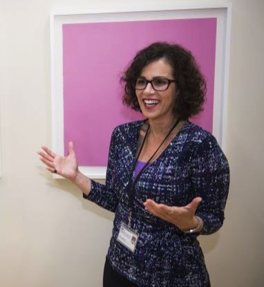 Julia Langley speaks in front of a color field painting