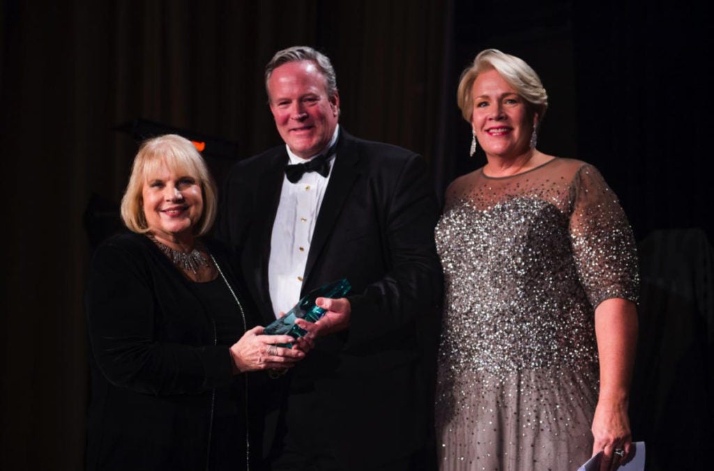 Three people stand together at an event