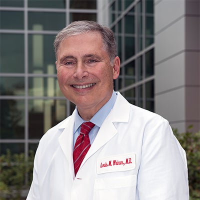 Dr. Louis Weiner pictured with glass building facade in the background