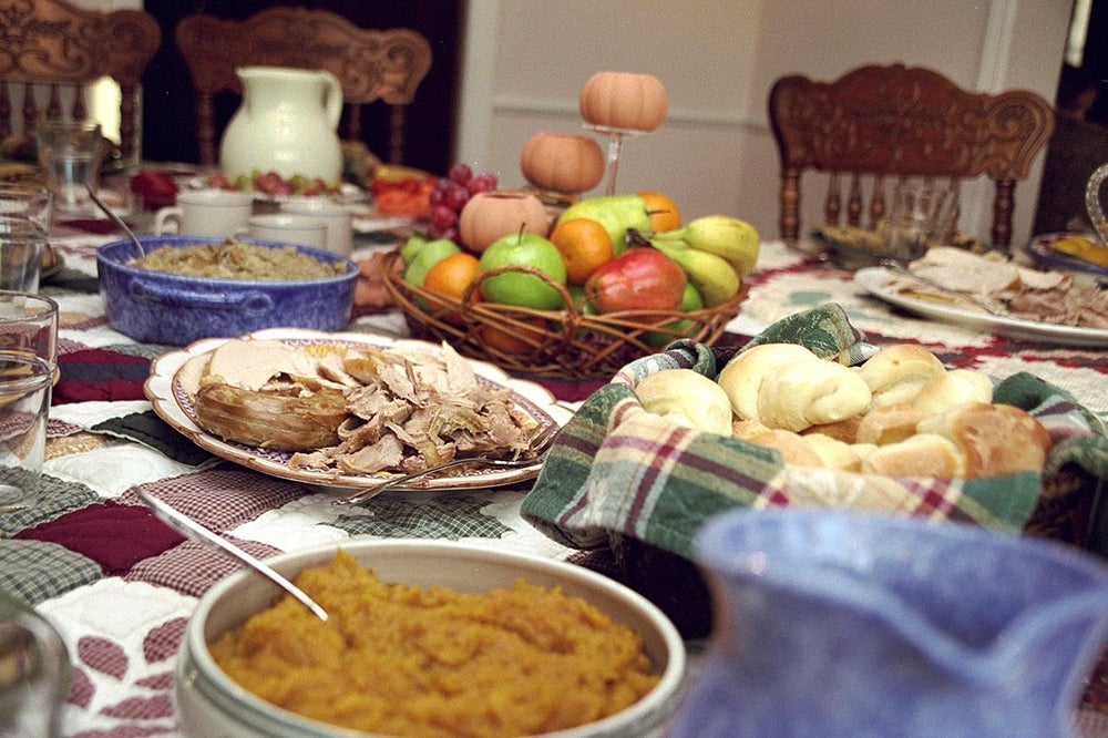 A table spread with dishes of traditional Thanksgiving foods