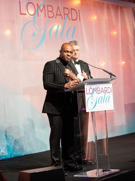 DeMaurice Smith and Vincent Lombardi II speak from a podium at the gala