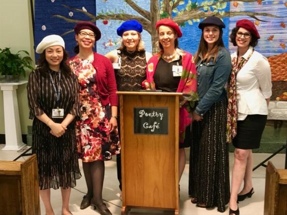 Poetry Café committee members (comprised of staff from the Department of Mission and Pastoral Care and the Georgetown Lombardi arts and humanities program) pose around the podium in the hospital chapel where Poetry Café is held.