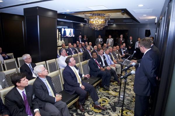 A room filled with people listening to a briefing