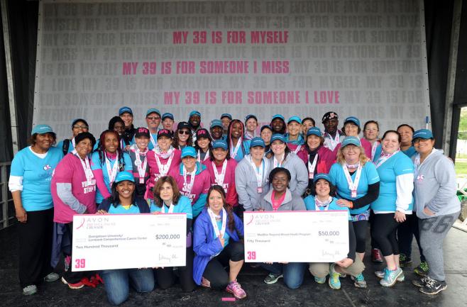 A group of people at a breast cancer charity walk hold signs