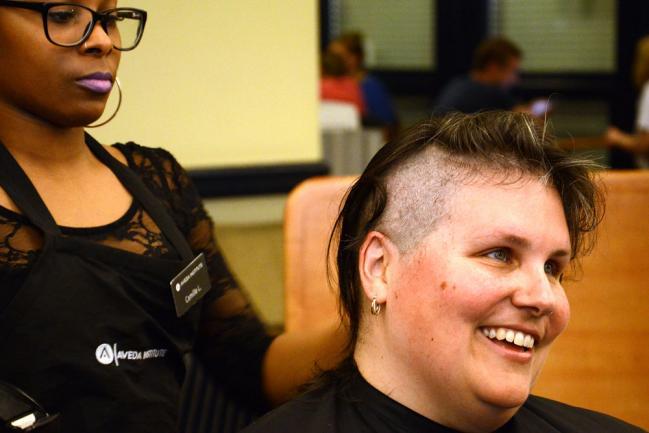 A woman gets her head shaved