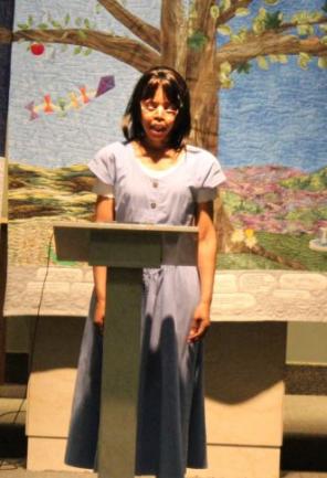 A woman speaks from behind a podium