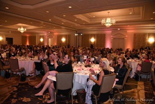 A ballroom filled with people seated at tables