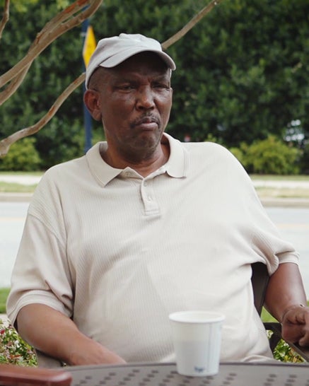 A man sits at a table outdoors