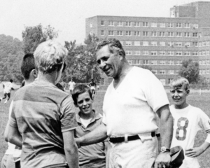 Vince Lombardi is pictured with a group of boys on a football field
