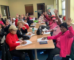 Women sit at tables for a Capital Breast Care Center community workshop