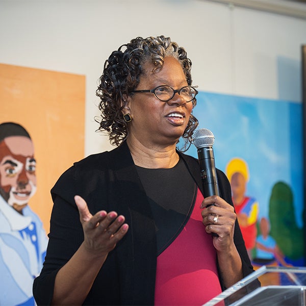 Lucile Adams-Campbell speaks into a microphone at a podium