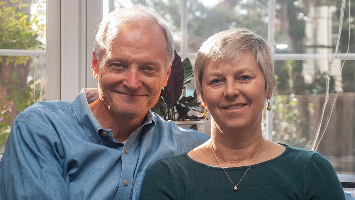 John and Liza Marshall sit side by side in their home