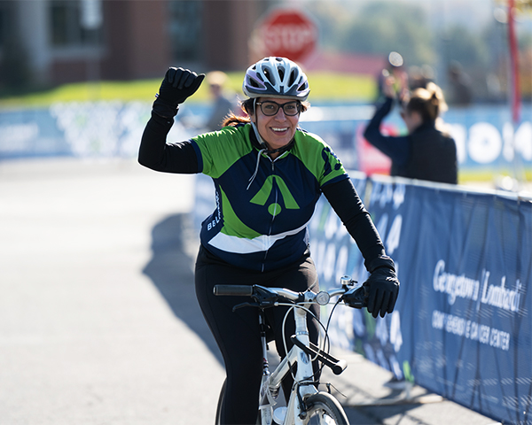Justine Weissenborn raises a hand in victory as she finishes riding