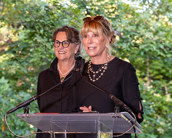 Two women stand behind a podium