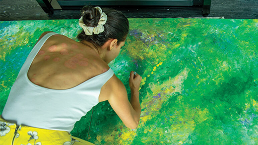 A woman paints a canvas