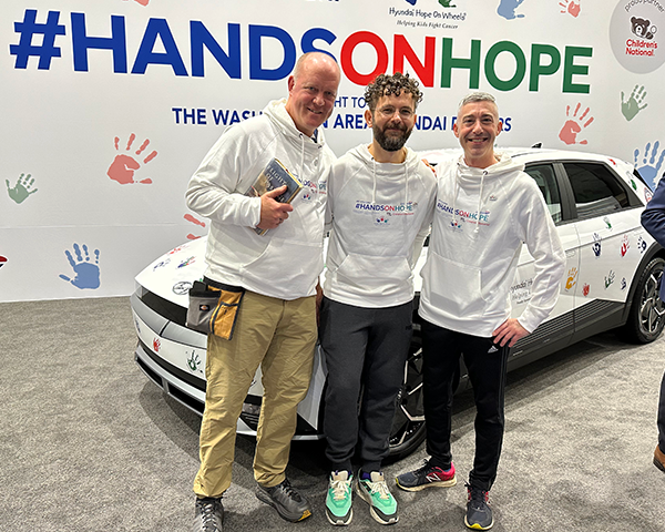 The three Georgetown Lombardi contestants stand together in front of the car prior to the start of the Hands On Hope Contest