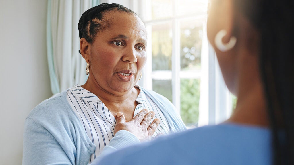 A woman talks seriously with her caregiver
