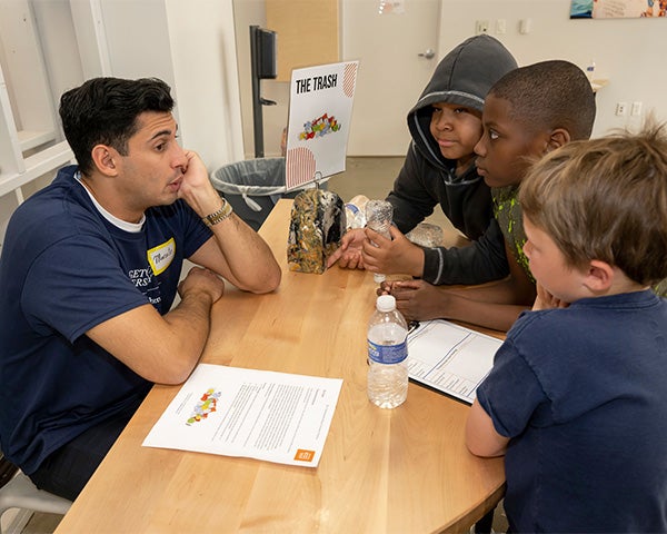 Marcelo speaks with a group of three children