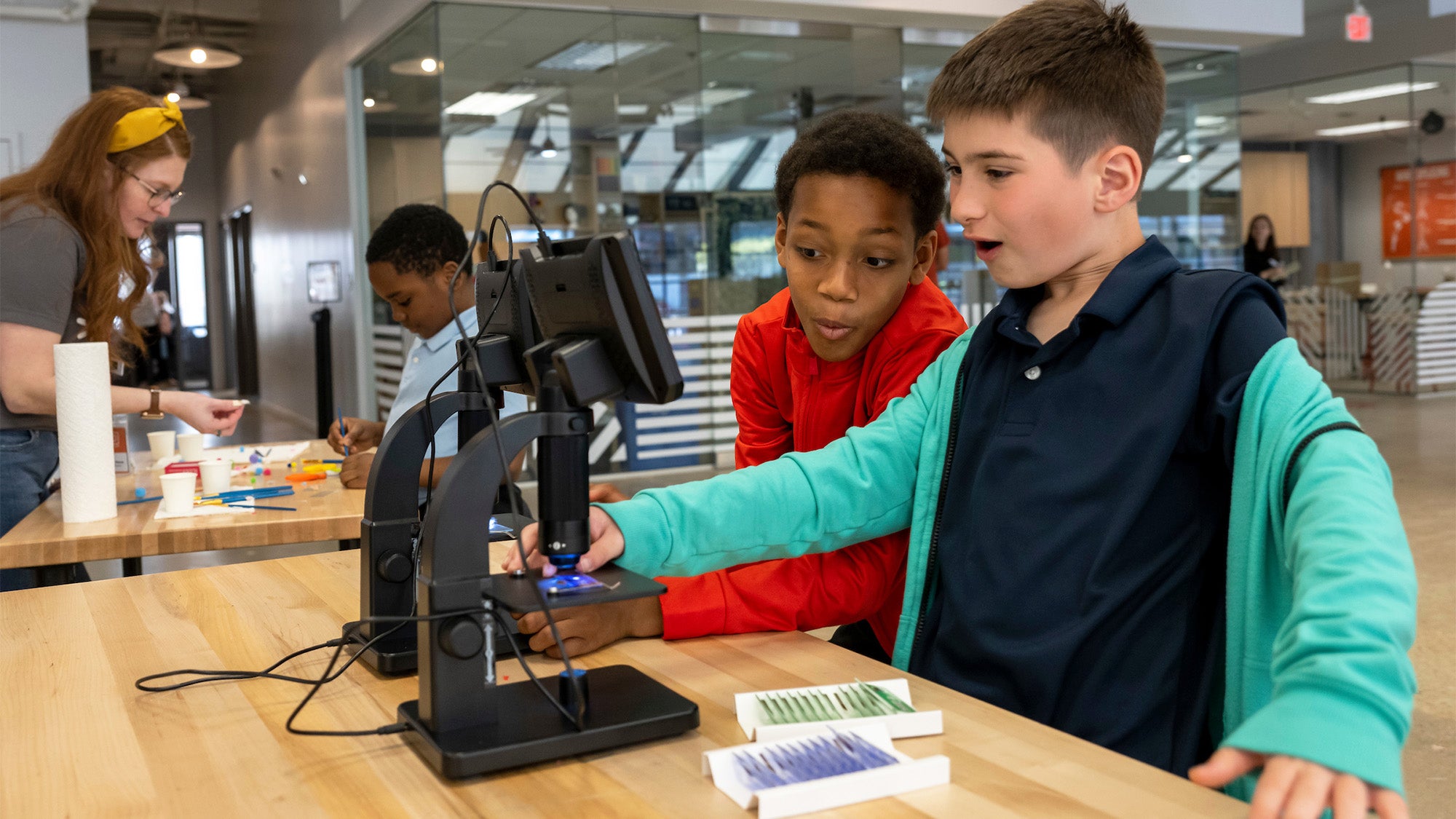 Two boys use a microscope