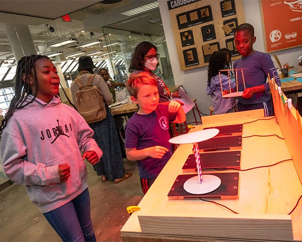 Students place cardboard creations on a table designed to measure how well they block the light