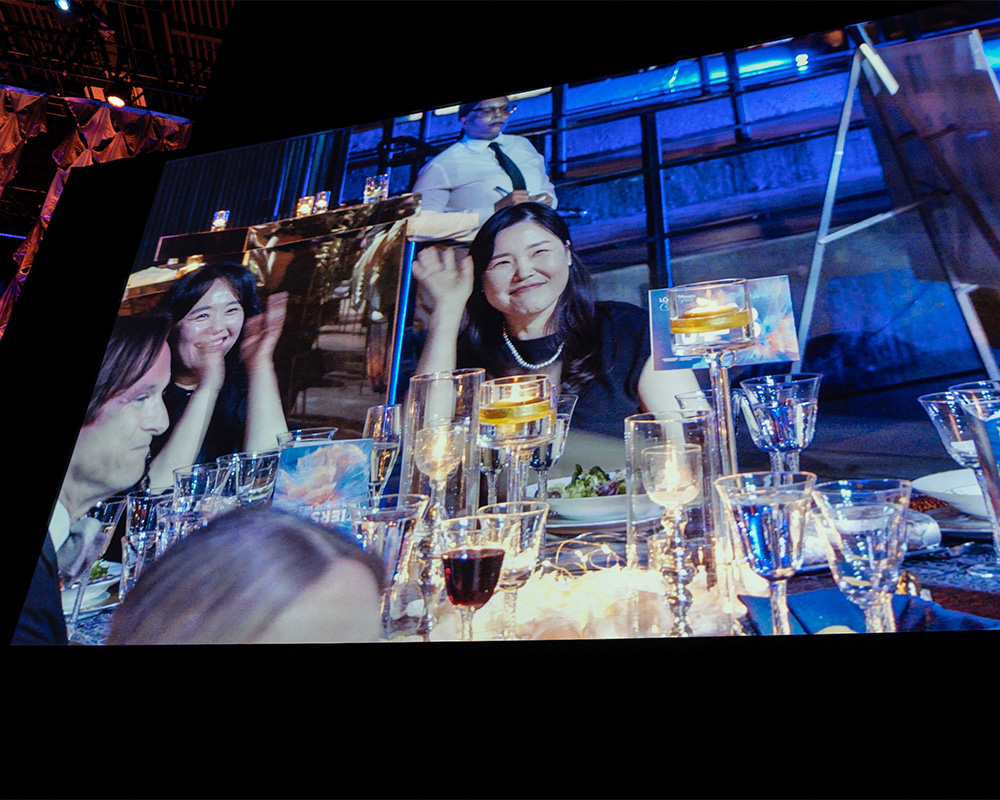 Cecil Han's image is projected onto a screen at the gala