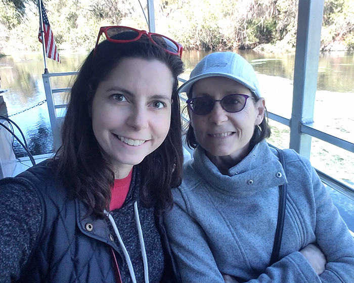 Claire Conley and her mother sit side by side on a boat cruising a river