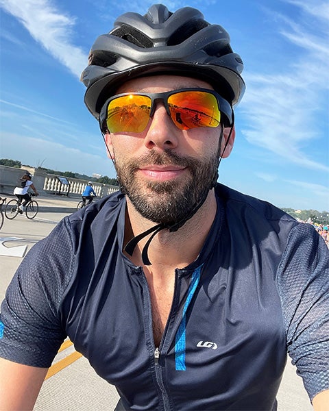 Fitz Lufkin in bike helmet, jersey and tinted sunglasses