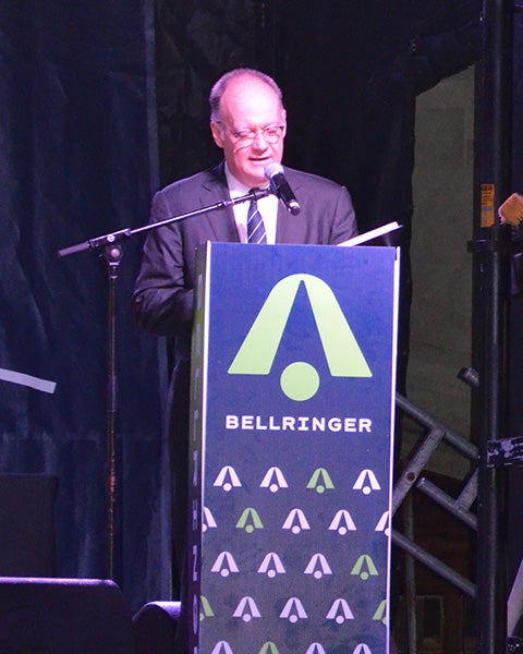 Jack DeGioia speaks from a podium on a stage