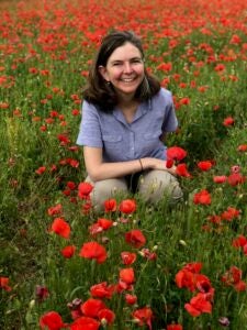 Image of author Gretchen E. Henderson in field of red flowers.