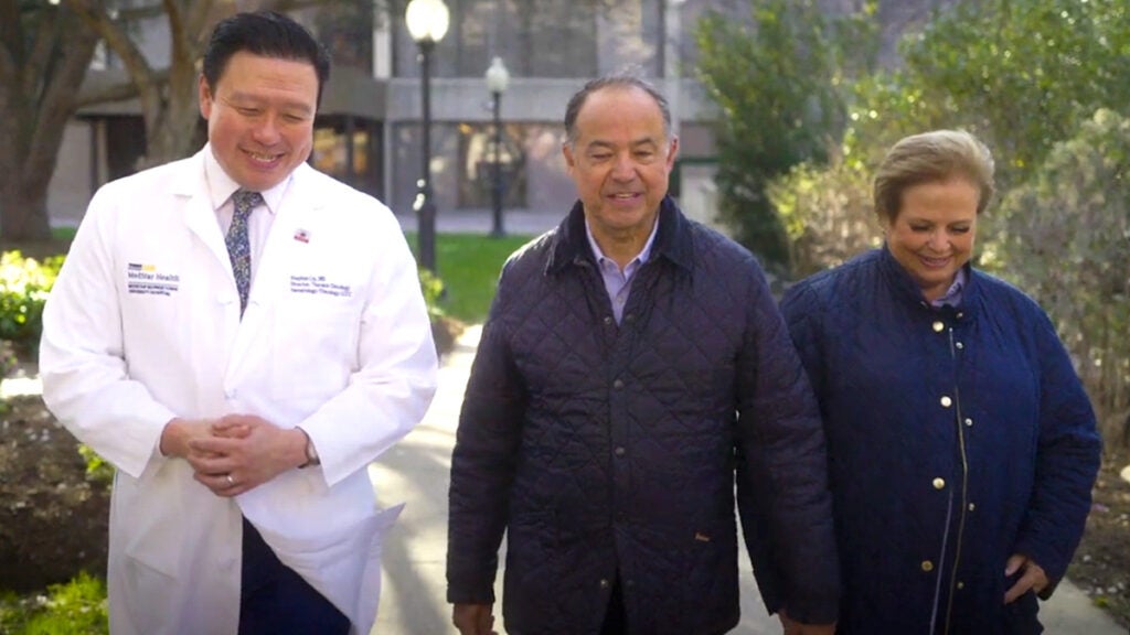 Dr. Liu and Jaime and Lourdes Posada walk together on Georgetown's campus