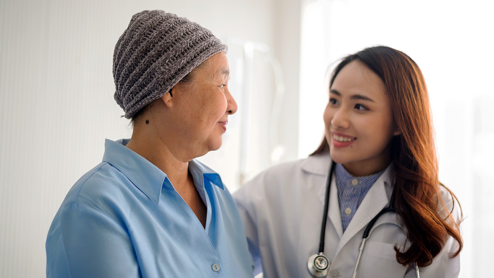 A doctor smiles at a patient undergoing treatment for breast cancer