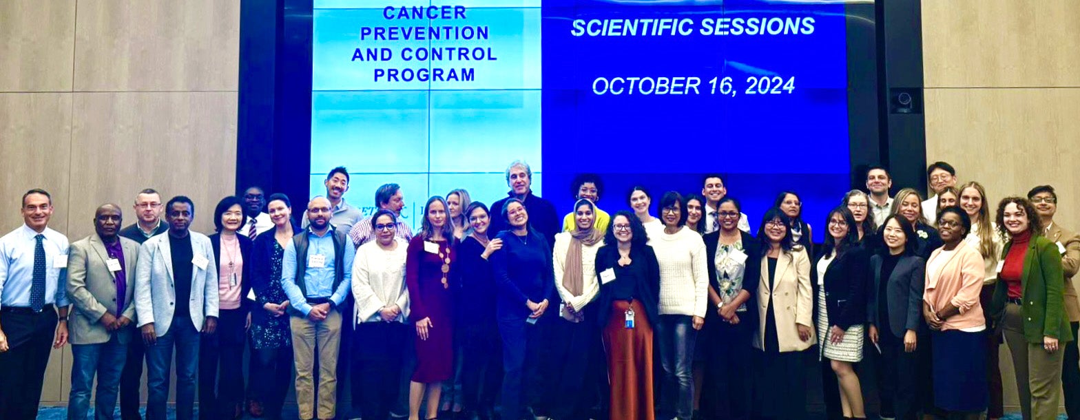 CPC Program members stand together on the stage in a large room