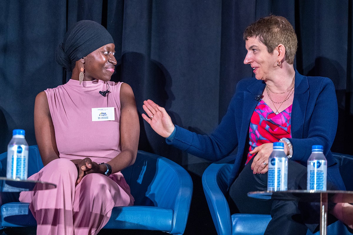 Alina Droughon and Claudine Isaacs speak with each other onstage