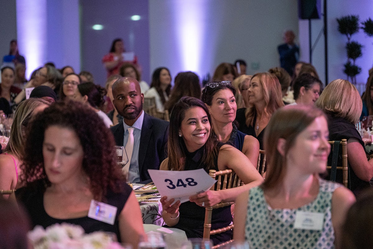 Attendees smile as they participate in the live auction