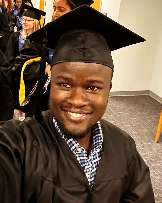 David Seeh is a Black man pictured in graduation regalia