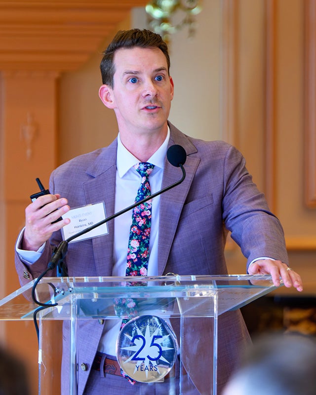 Ryan Hankins, MD, speaks from a podium during the Men's Event