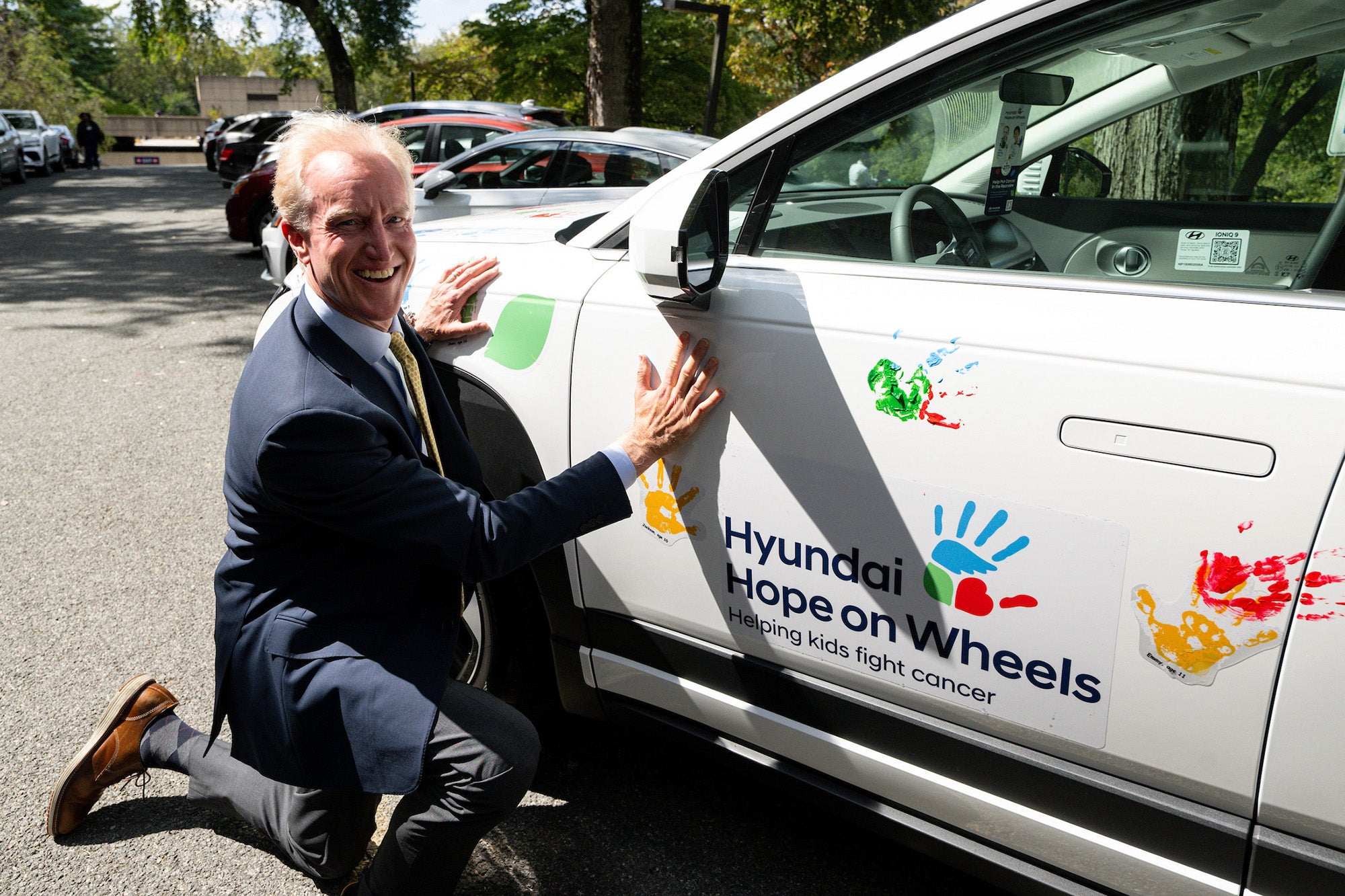Kevin Reilly presses his palm against a white car