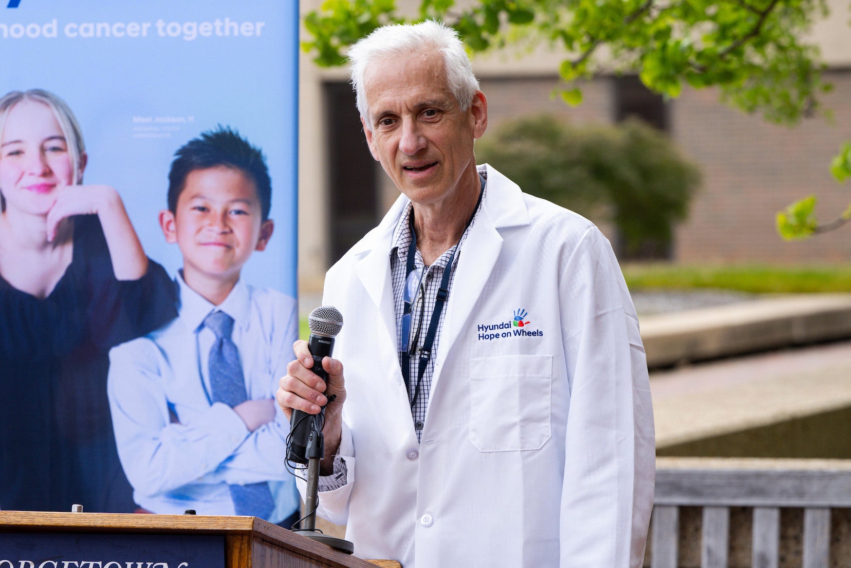 Dr. Kupfer speaks from a podium outdoors
