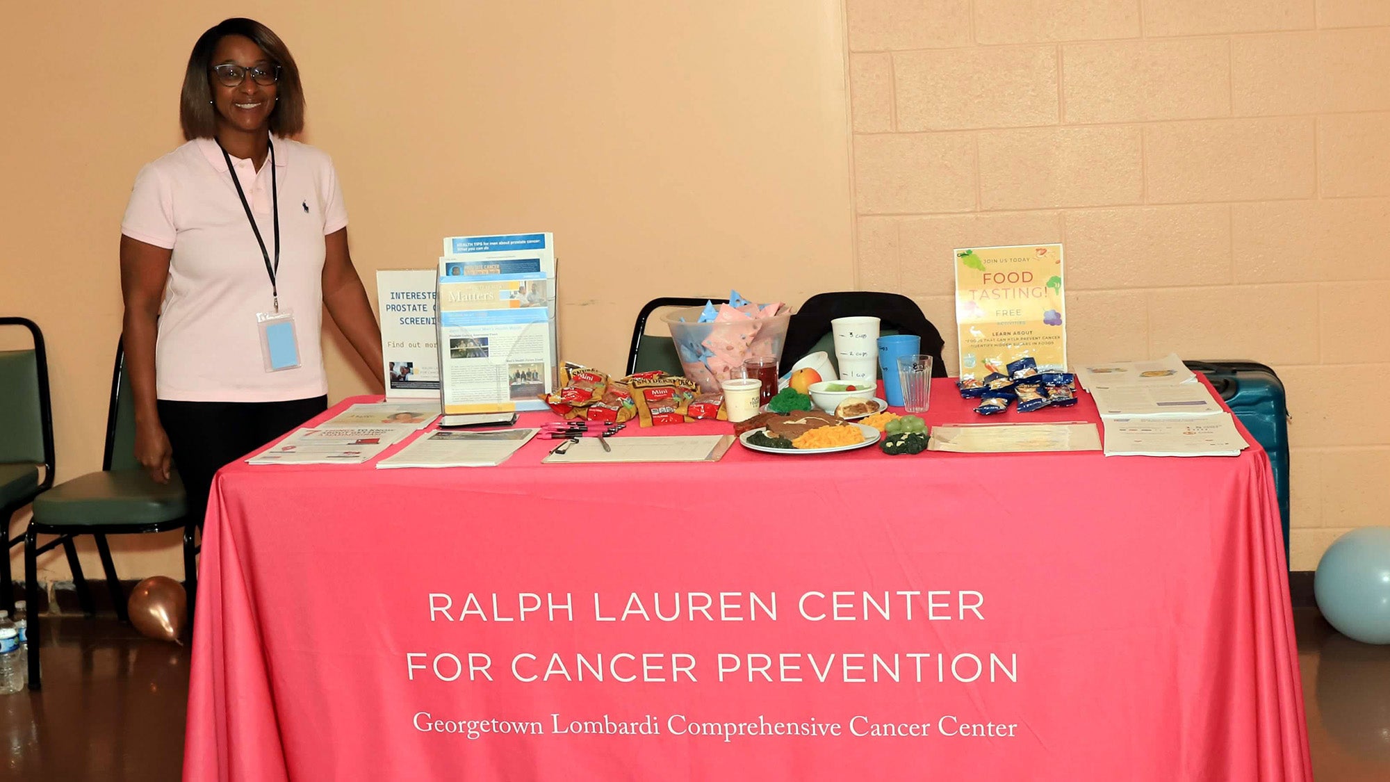 Mireille Bright stands next to the Ralph Lauren Center's table at a health fair