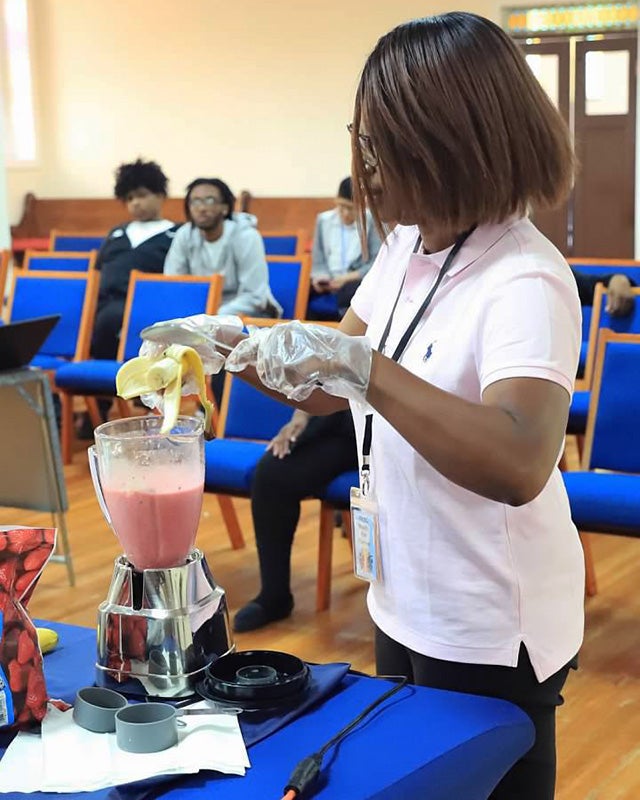 Mireille Bright makes a smoothie as a demonstration in front of a church audience