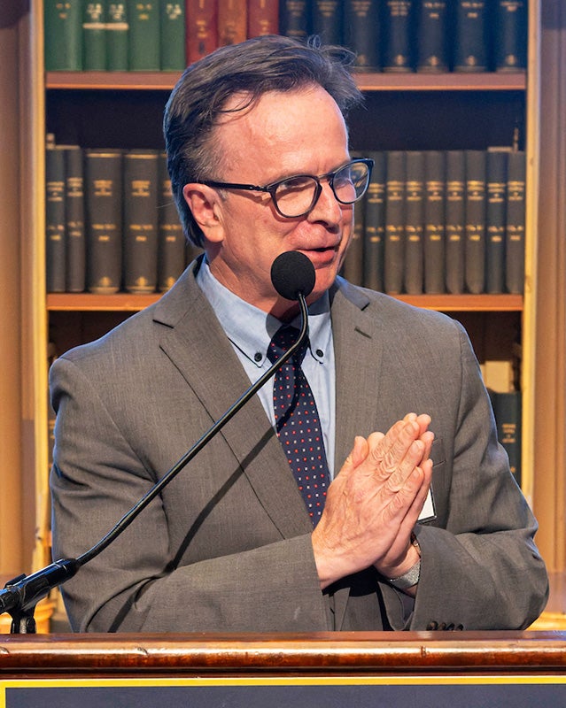 Norman Beauchamp speaks from a podium in Riggs Library